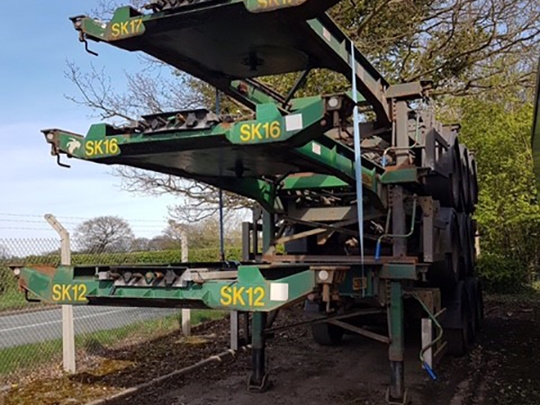 stacked up green skeleton trailers from front